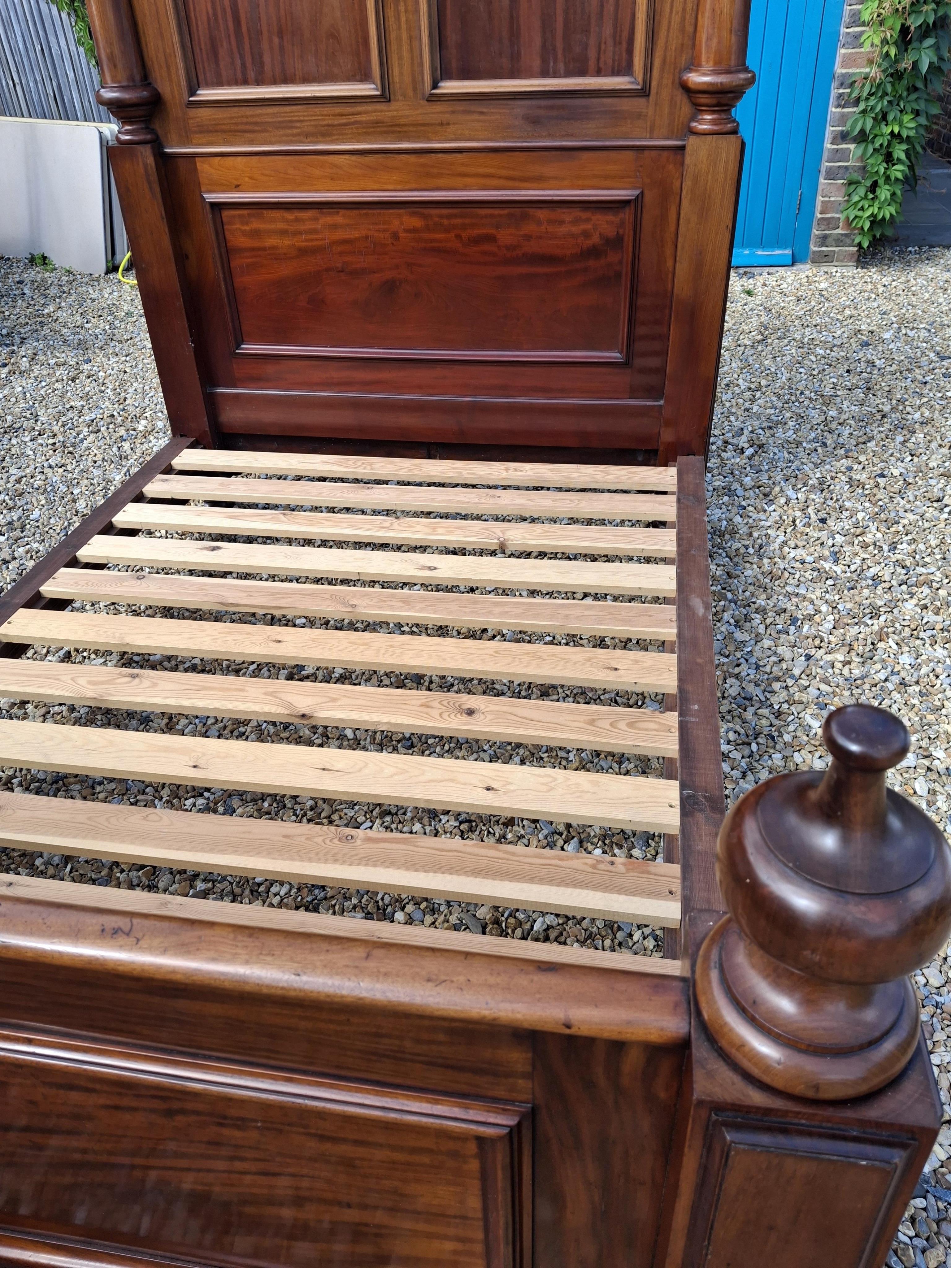 A Victorian mahogany bed frame, width 151cm, height 242cm accompanied by cream jacquard bed cover, cushions and bolsters